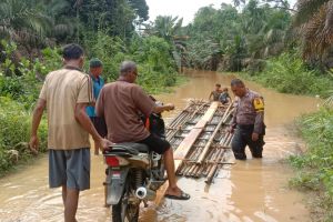 Jalan Desa Siambul Terendam Banjir, Bripka Habibi Berendam Bantu Warga