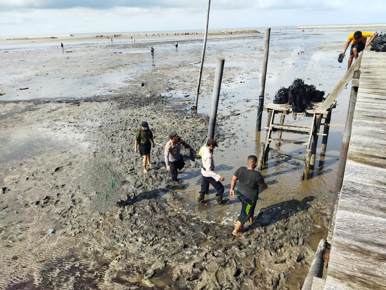 Lewati Lumpur, Kapolsek Bantan Temui Warga di Pesisir Pantai Selat Malaka